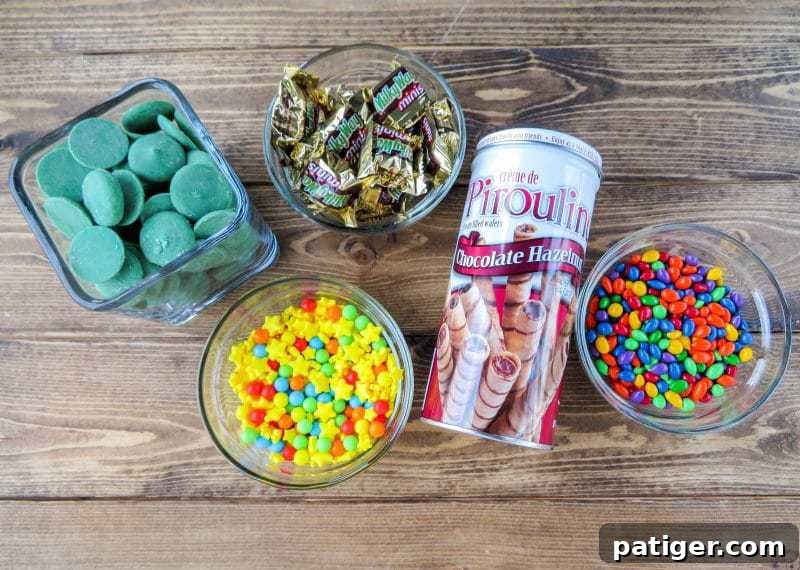 Ingredients for making easy no-bake Christmas tree treats, including candy melts, wafers, and various candies.