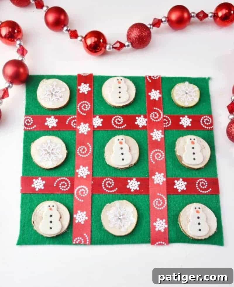 Close-up of a festive DIY Christmas Tic Tac Toe board made from felt and ribbon with snowman and snowflake game pieces.