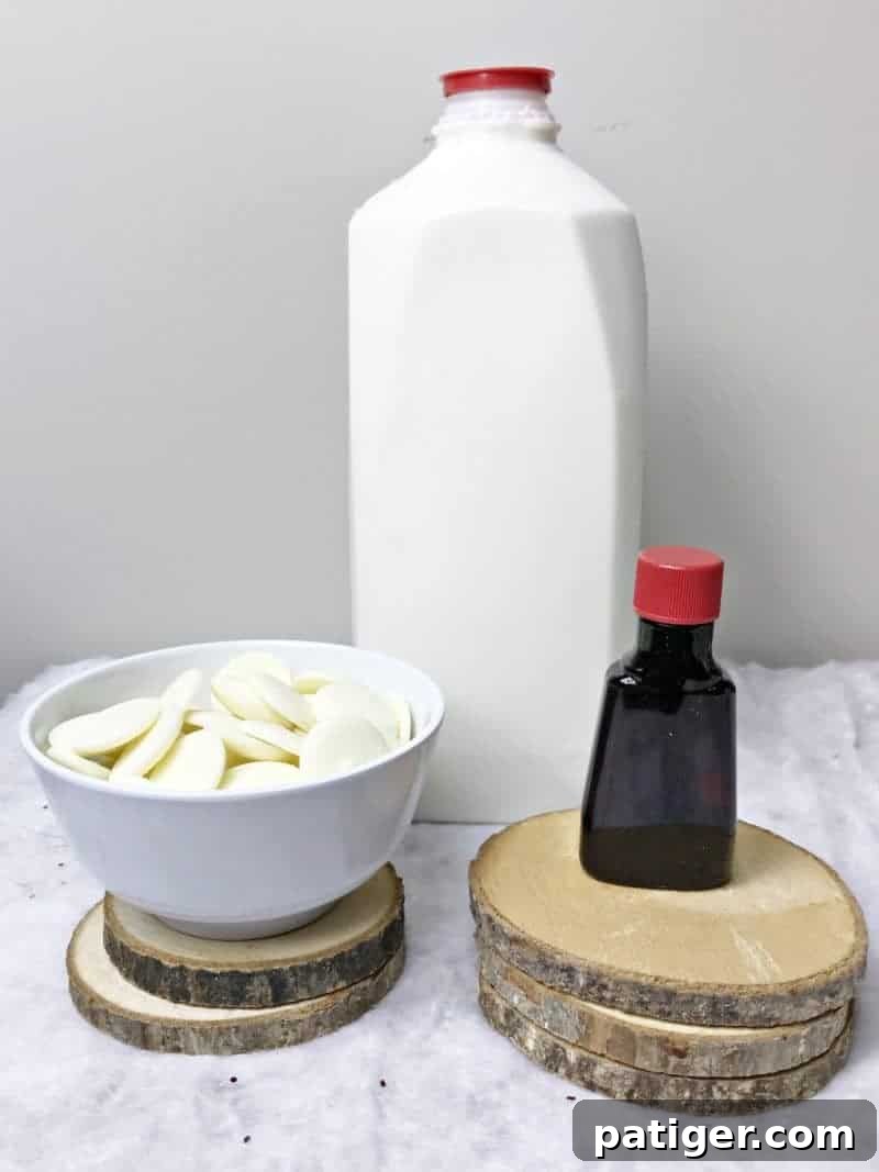 Ingredients for homemade white hot chocolate laid out: milk, white chocolate melting wafers, and pure vanilla extract.