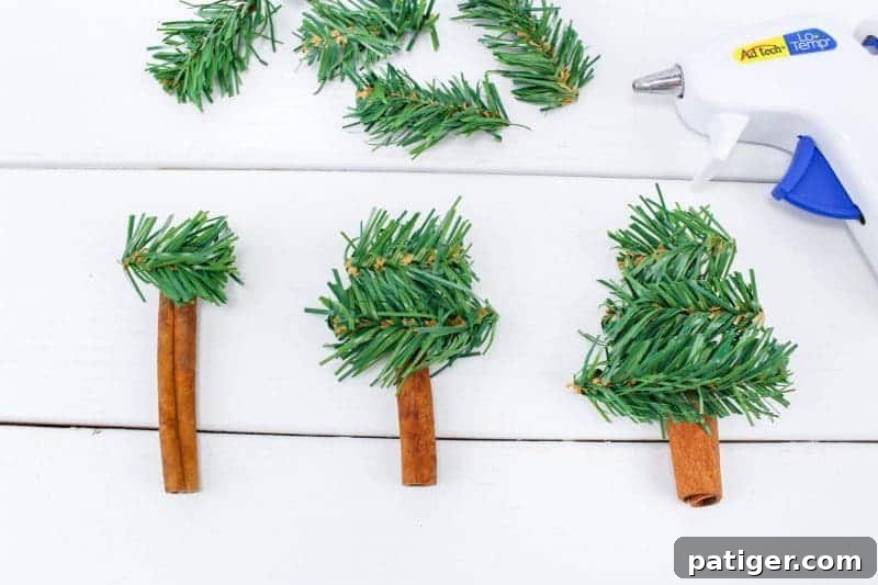 Second step of the DIY ornament craft: gluing the cut garland pieces onto the cinnamon stick in a tree formation.