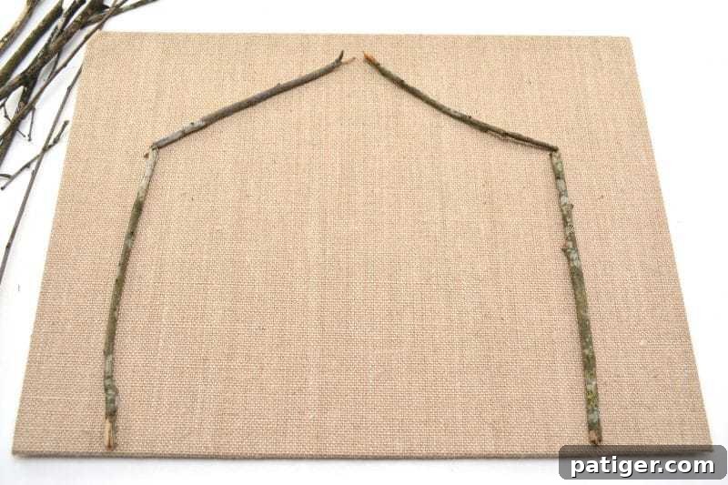 Pebble Art Nativity Canvas 4 Start your DIY Rock Nativity Canvas by arranging twigs on the burlap canvas to form the stable, ensuring it's large enough for all your chosen characters.