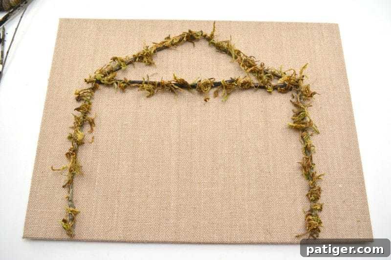 Pebble Art Nativity Canvas 5 Secure the twig stable with hot glue and add floral moss to the base for a natural, rustic feel on your DIY Rock Nativity Canvas.