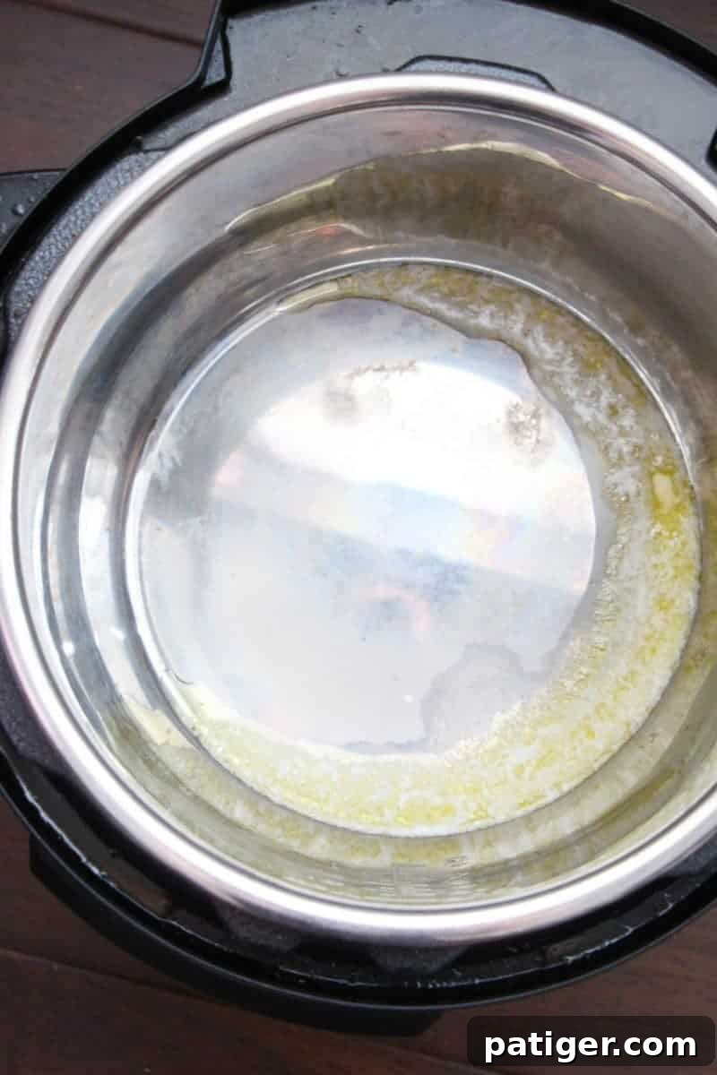 Garlic Butter Instant Pot Shrimp Scampi 5 Oil and butter melting in the Instant Pot on Saute mode, creating the fragrant base for the scampi sauce.