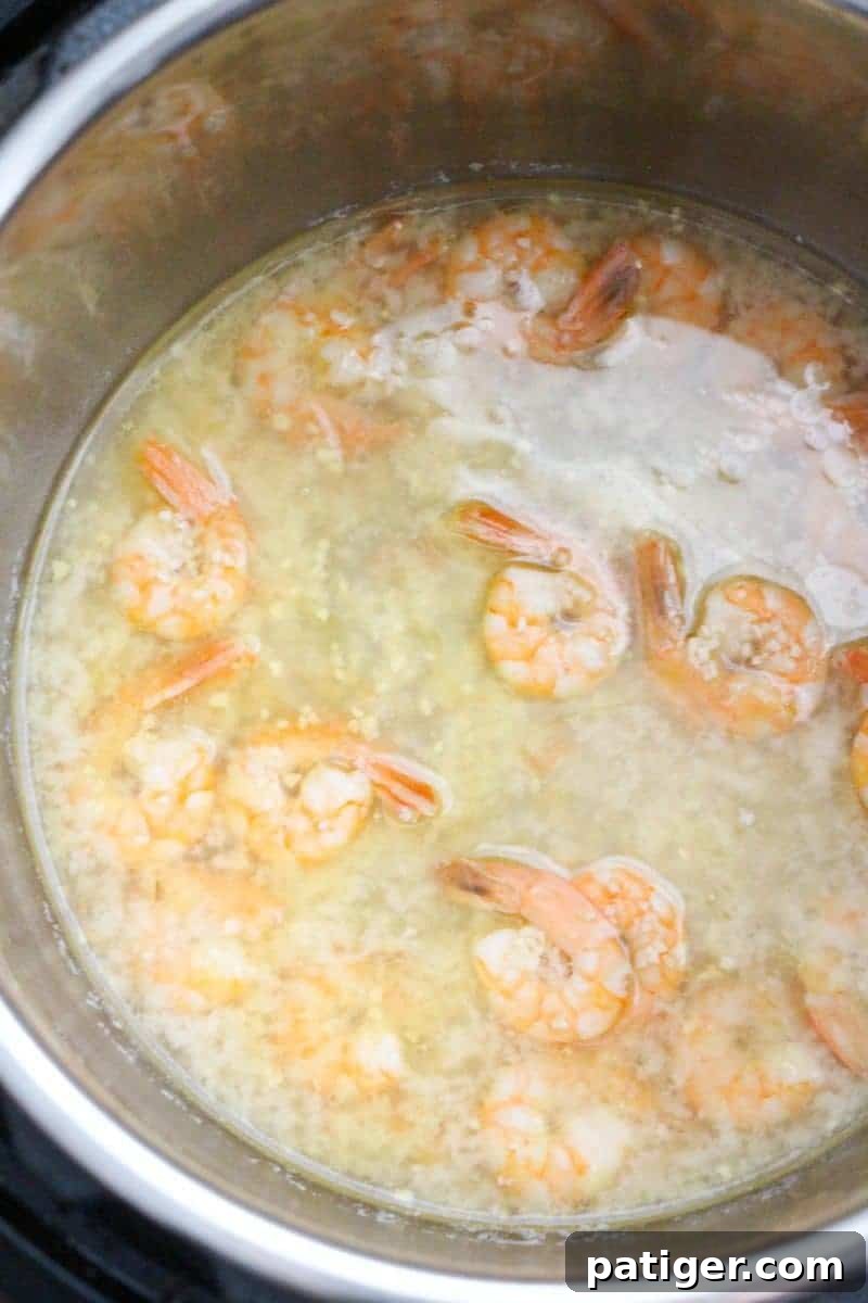 Garlic Butter Instant Pot Shrimp Scampi 7 Fresh shrimp added to the Instant Pot with the aromatic liquid, ready for quick pressure cooking.
