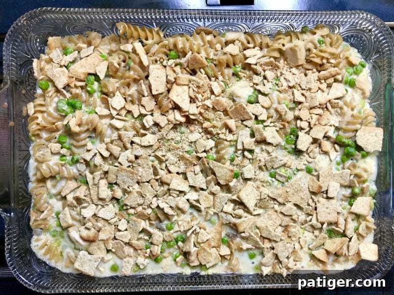 Guilt-Free Tuna Pasta Bake 8 The tuna pasta casserole with its whole grain cracker topping sprinkled on, poised for its final bake to achieve a golden crisp.