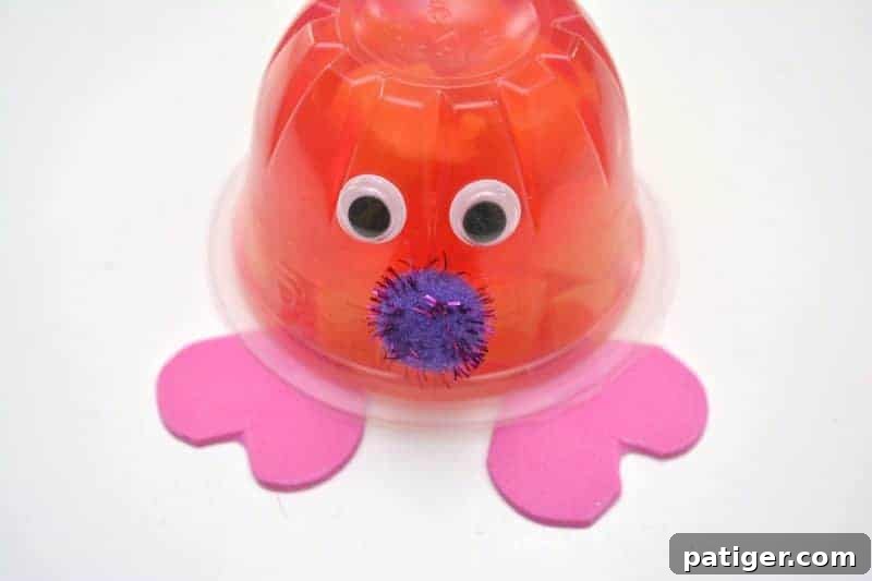 Fruity Love Bug Valentine Treats 11 Step 7: Attaching two heart-shaped foam feet to the bottom of the inverted snack cup.