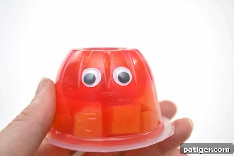 Fruity Love Bug Valentine Treats 6 Step 2: Gluing googly eyes onto the inverted snack cup.