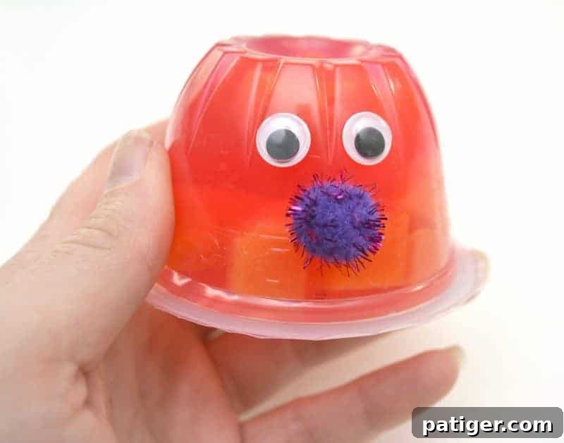 Fruity Love Bug Valentine Treats 7 Step 3: Attaching a small sparkly pom pom as the love bug's nose.