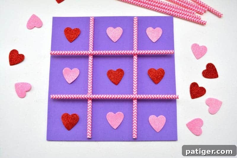 XOXO Tic Tac Toe 3 Child holding a finished Valentine's Day Tic Tac Toe game with heart-shaped pieces