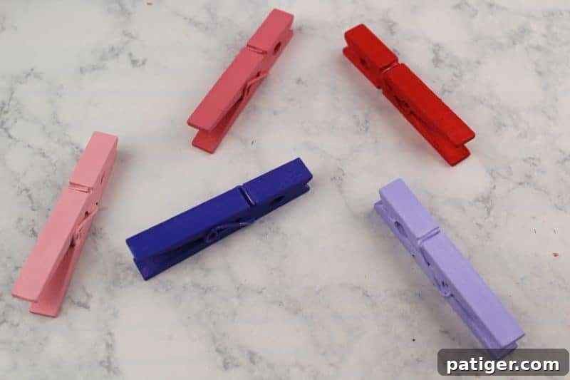 Painted clothespins laid out to dry, ensuring the color sets before further decoration