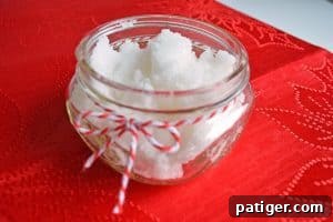 Homemade peppermint sugar scrub in a glass mason jar, decorated for gifting