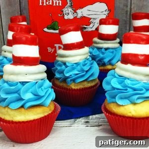 Cat in the Hat themed cupcake with blue frosting and an iconic red and white striped hat topper.