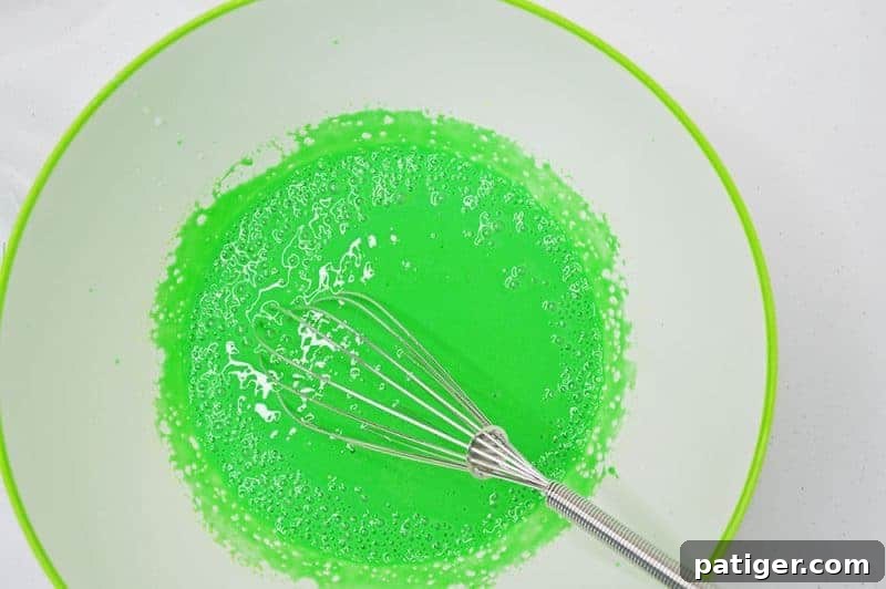 Magically Delicious St Patricks Day Pudding Parfaits 6 Adding green gel food coloring to the whisked pudding mixture