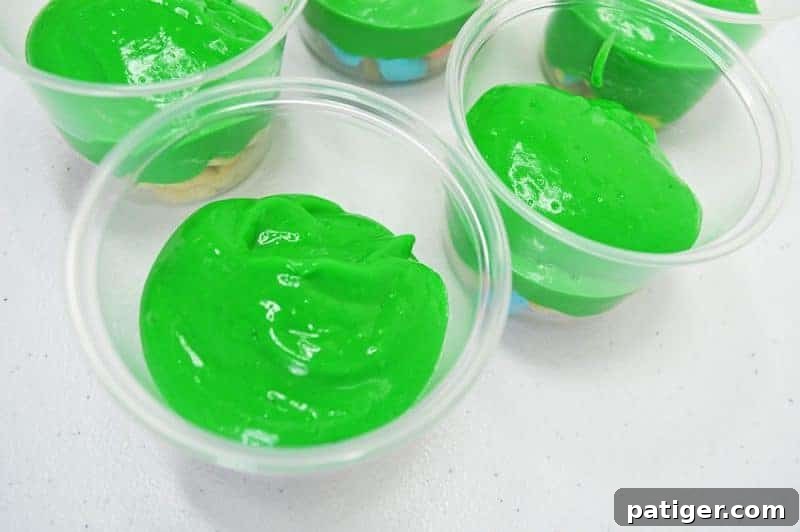 Magically Delicious St Patricks Day Pudding Parfaits 8 Adding the first spoonfuls of green pudding over the Lucky Charms layer