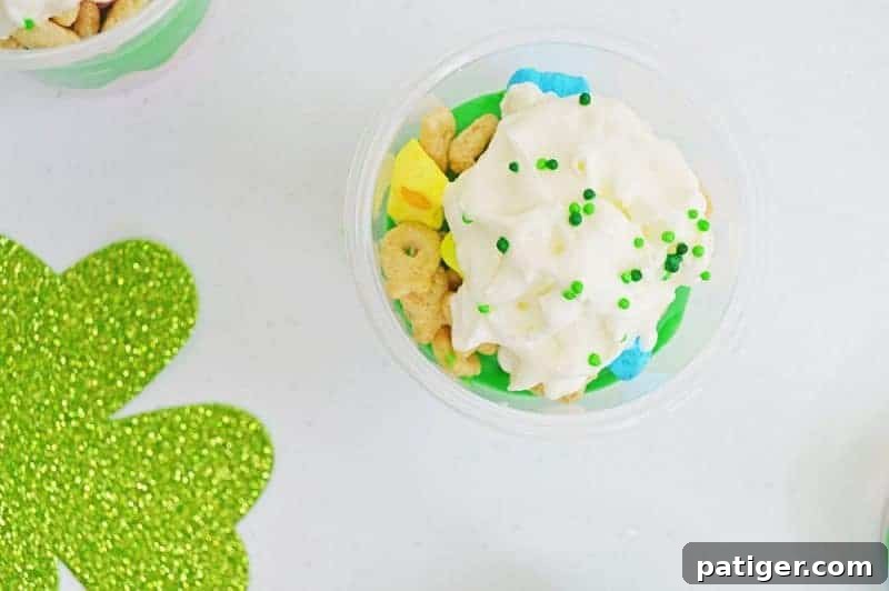 Magically Delicious St Patricks Day Pudding Parfaits 10 Finishing St. Patrick's Day Pudding Parfaits with whipped cream and green sprinkles