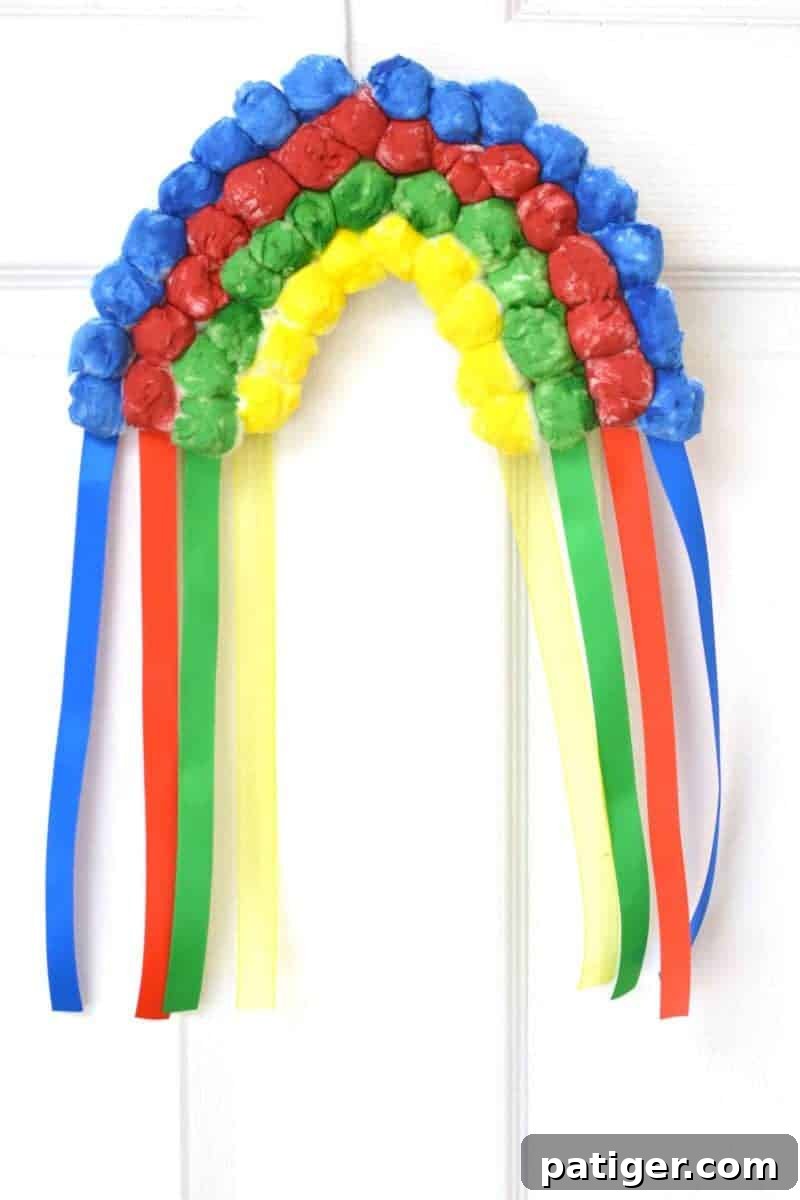 Finished hanging cotton ball rainbow craft with ribbon streamers