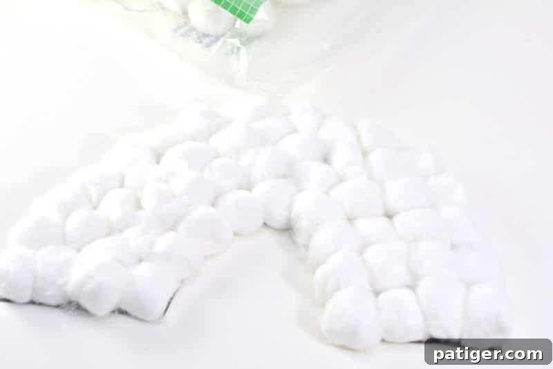 Kids gluing cotton balls onto rainbow base