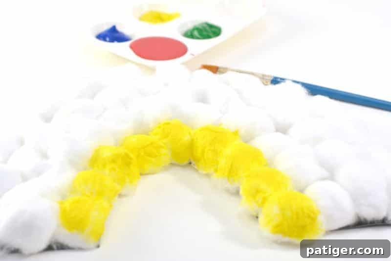 Painting cotton balls vibrant rainbow colors