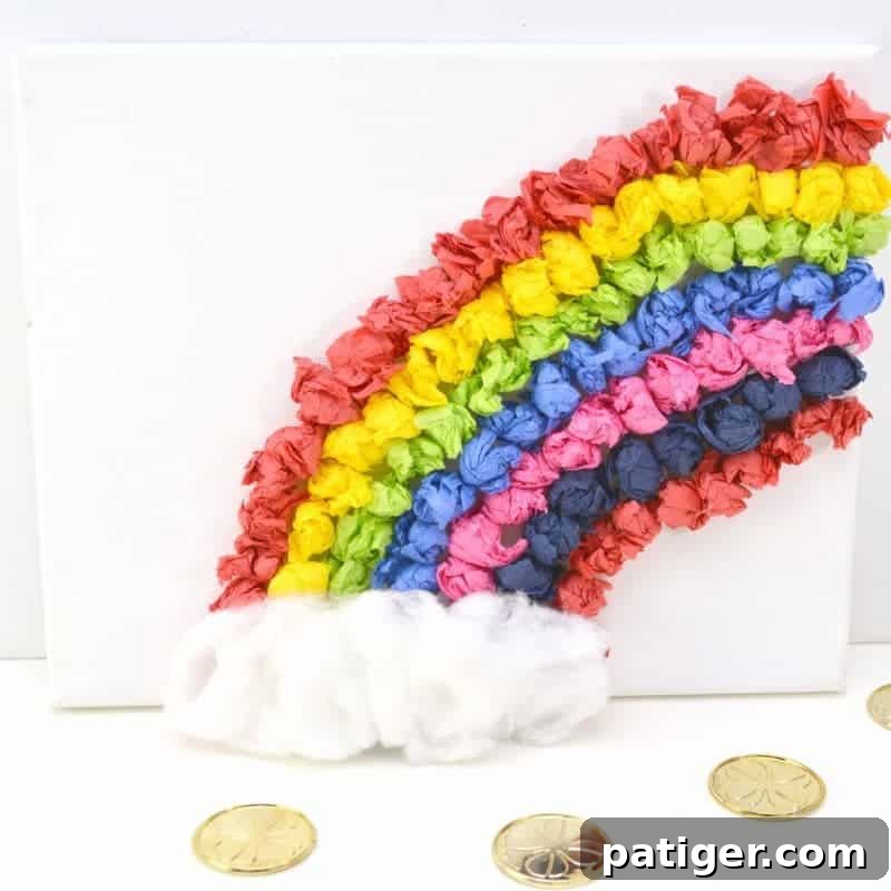 Rainbow Tissue Paper Magic 2 Brightly colored rainbow tissue paper craft on a white canvas, featuring fluffy cotton ball clouds at the base, perfect for kids' creative projects.