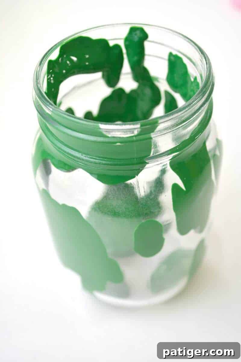 Pouring green paint into a mason jar