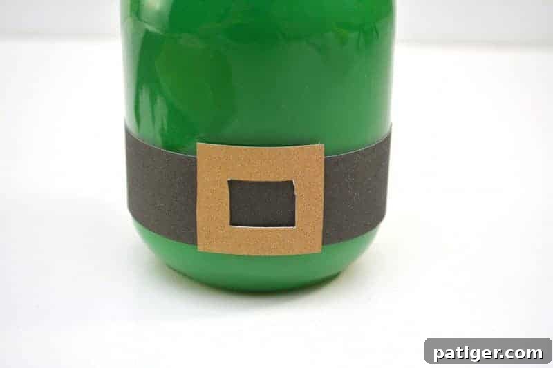 Gluing the gold glitter square buckle onto the black glitter strip on the jar