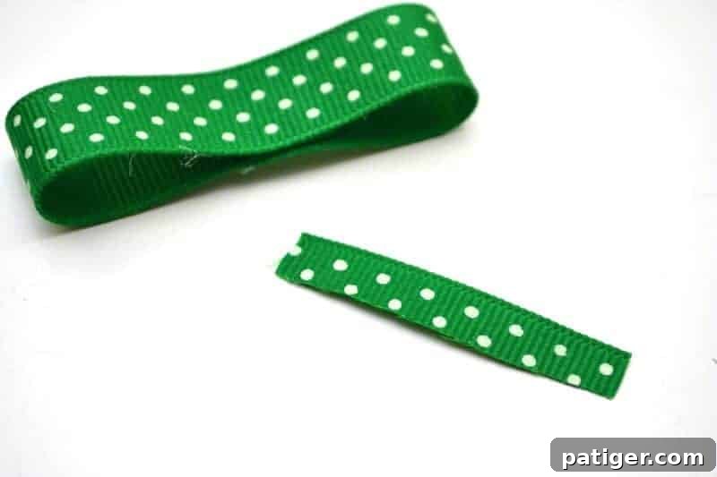 Folding the second side of the green ribbon to complete the bow shape