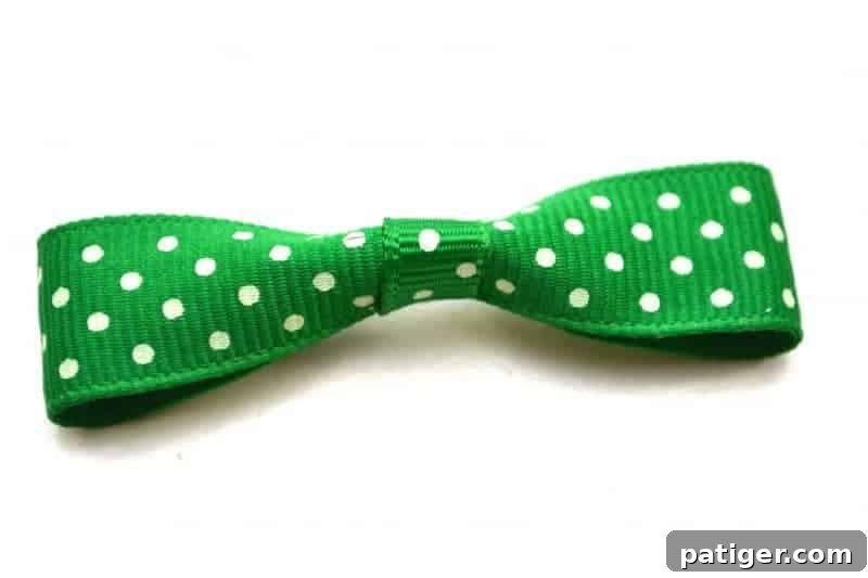 Gluing the mini green bow tie to the top front of the mason jar