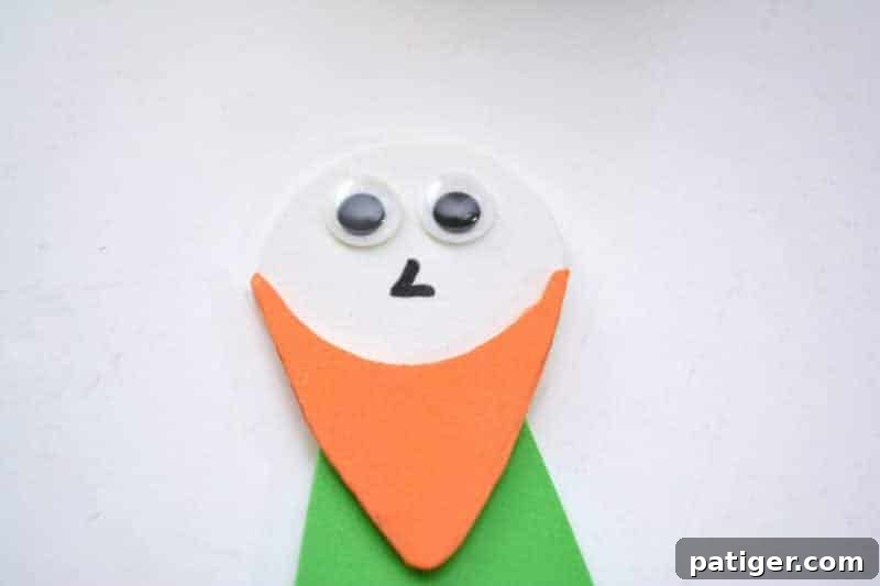 Craft a Lucky Leprechaun from Popsicle Sticks for St Patricks Day 12 Step 8: Adding personality to the leprechaun's face by drawing a small nose and securely gluing on two playful googly eyes.
