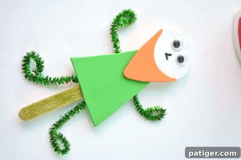 Craft a Lucky Leprechaun from Popsicle Sticks for St Patricks Day 14 Step 10: Attaching the pipe cleaner arms and legs to the back of the leprechaun's shirt and popsicle stick with glue, creating a dynamic pose.