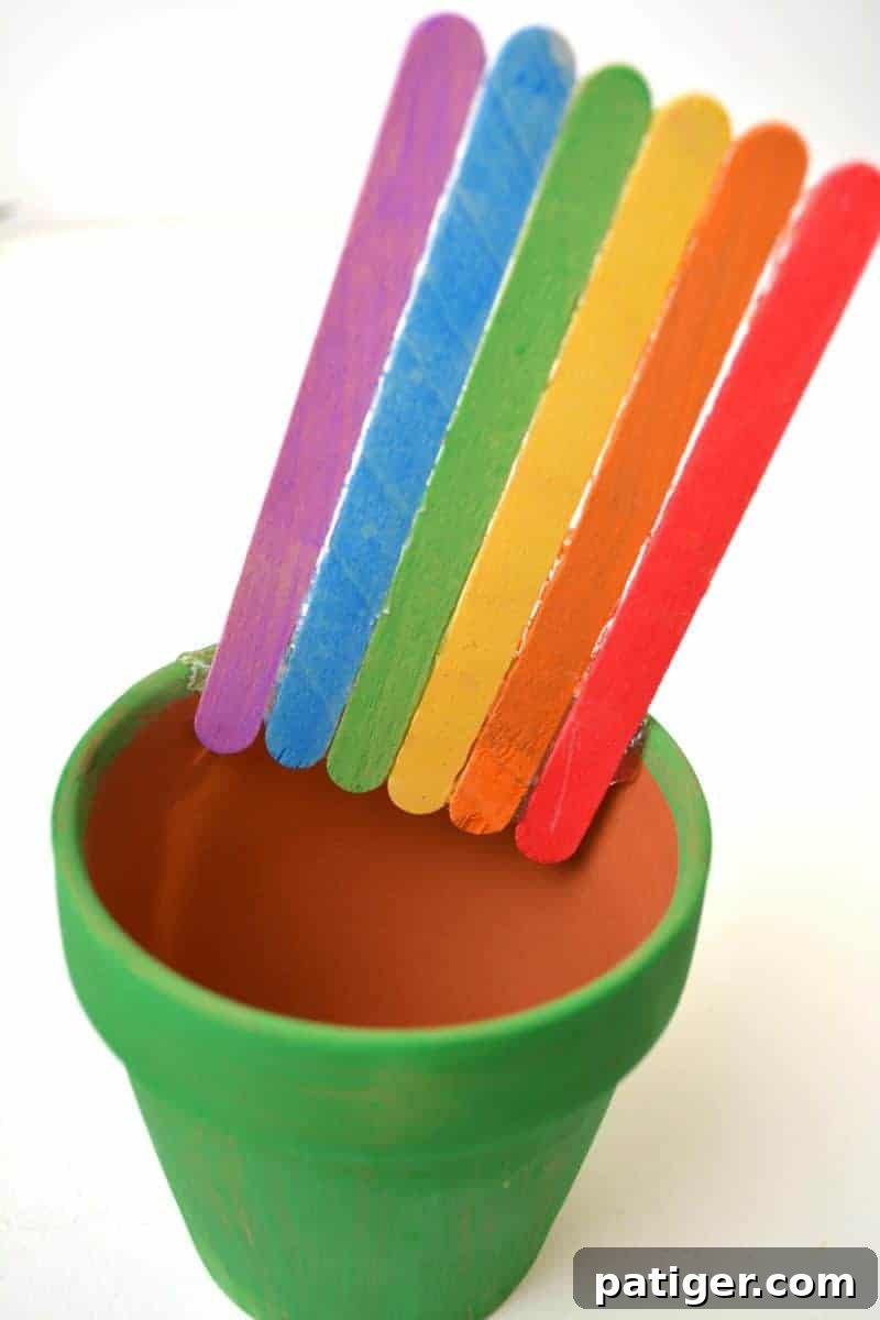 St Patricks Day Lucky Rainbow Gold Planter 7 A crafted rainbow glued at an angle inside the back of a green terra cotta pot, creating the illusion of a rainbow ending in a pot.