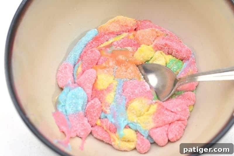 Melting sour gummy worms in a microwave-safe bowl, the first step for homemade edible silly putty.