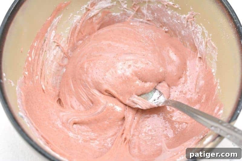 Gradually adding cornstarch to edible silly putty until it reaches a non-sticky, pliable texture.