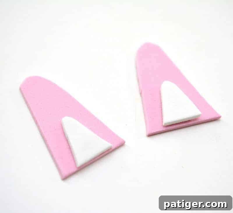 The process of gluing the white inner ear foam onto the pink outer ear foam, effectively creating multi-dimensional and realistic bunny ears for the pudding cup craft.