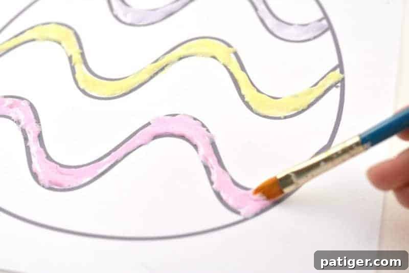 Child using a paintbrush to apply homemade Peeps puffy paint to an Easter egg coloring page.