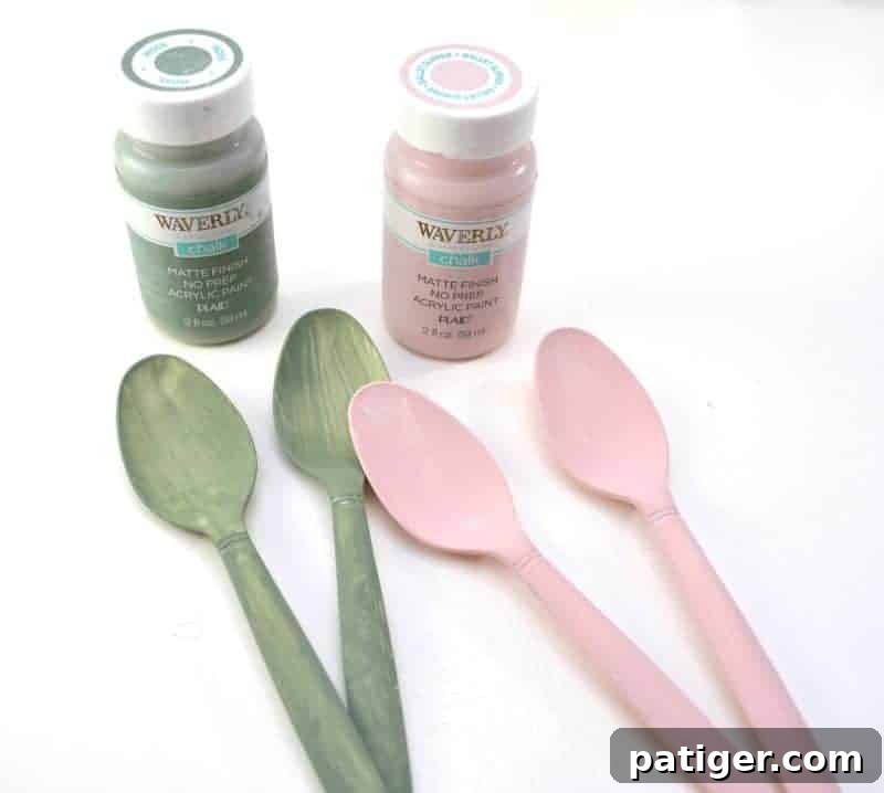 Child painting plastic spoons with craft paint in preparation for making Easter egg maracas.