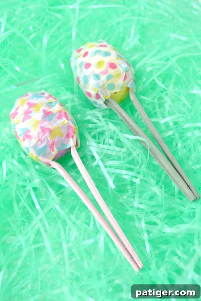A child happily shaking a finished homemade Easter egg maraca, decorated with colorful washi tape.
