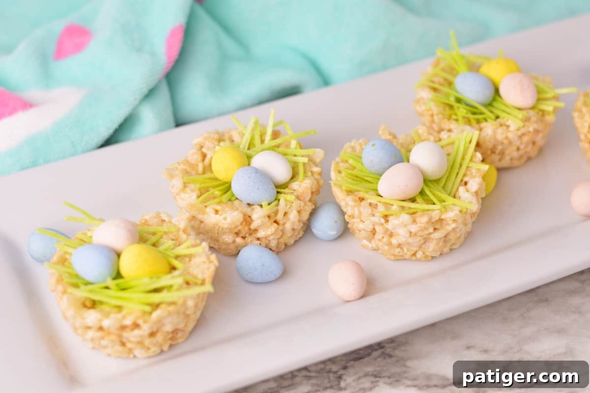 Four Rice Krispie Easter Nests on a white serving platter, beautifully decorated and ready to be enjoyed.