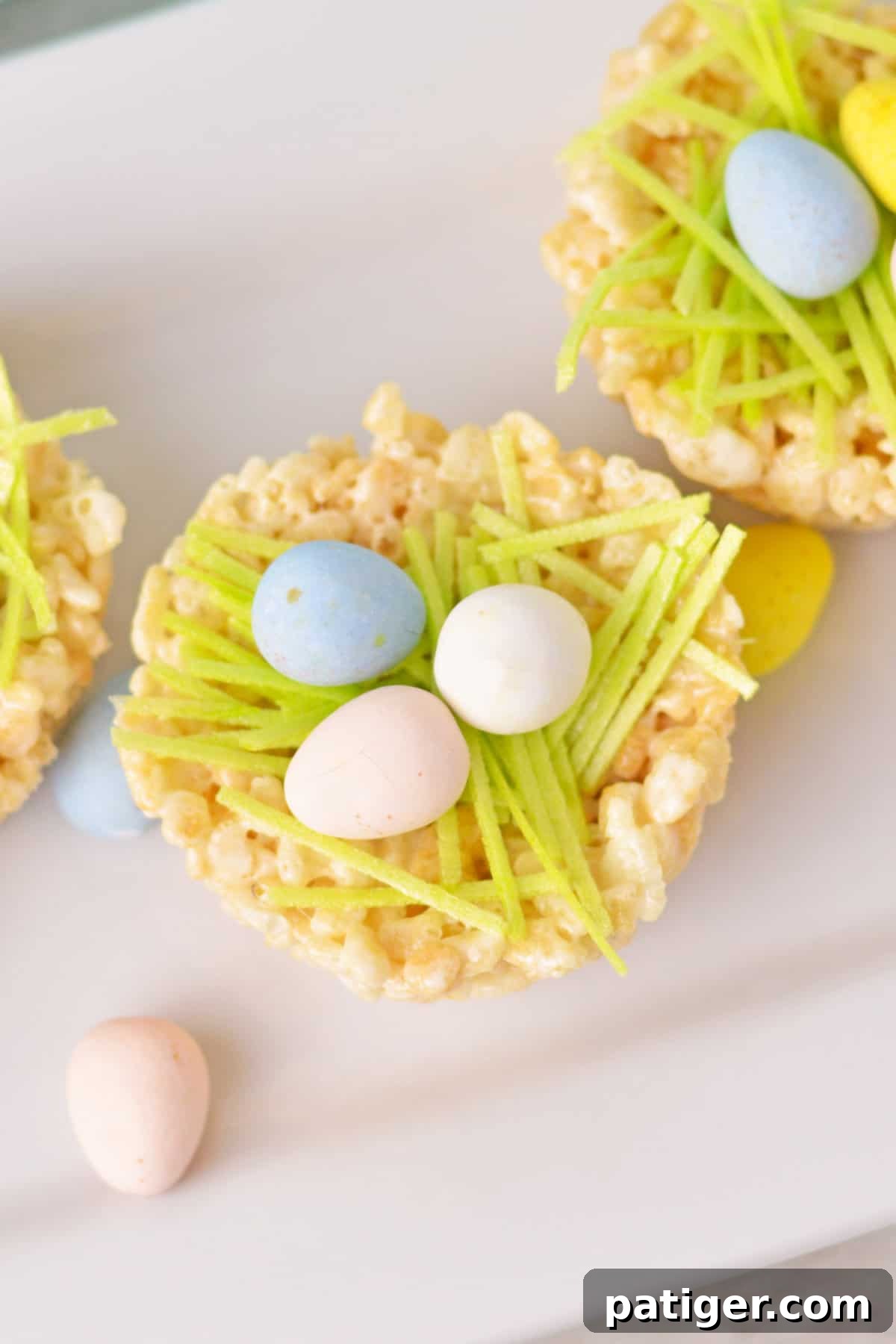 Overhead view of Rice cereal treat filled with cadbury mini eggs and green edible grass, highlighting the inviting details.