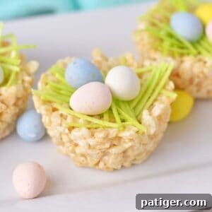 Rice krispie nests with mini eggs and edible grass, a delicious Easter treat.