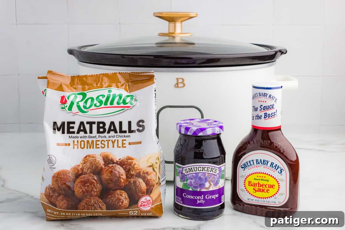 Ingredients for frozen meatballs in the crockpot, including a bag of frozen Rosina Homestyle Meatballs, a jar of Smucker's Concord Grape Jelly, and a bottle of Sweet Baby Ray's Barbecue Sauce. A white slow cooker with a black lid is in the background on a marble countertop.