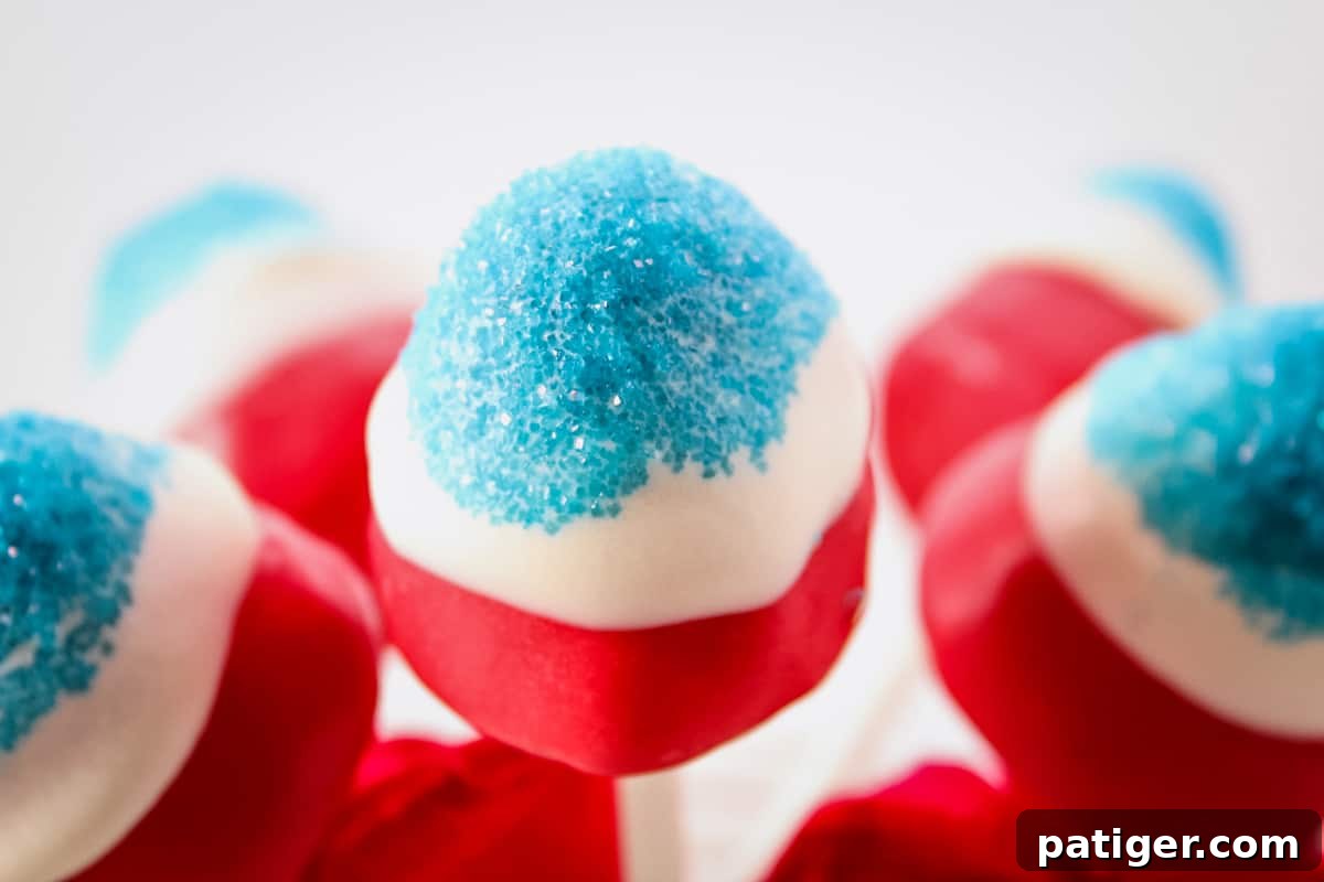 Close up of red and white candy coated strawberry with blue sanding sugar on the top.