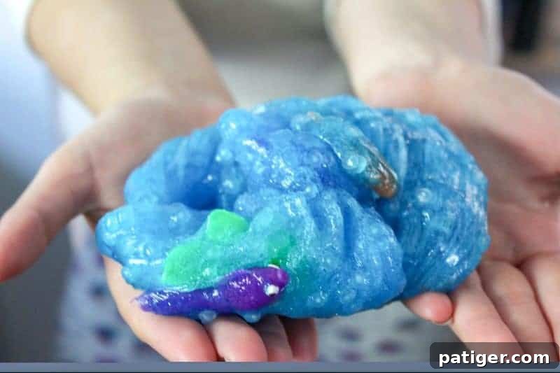 Close-up of ocean slime with embedded plastic fish, showcasing its thick, squishy texture and shimmering glitter.