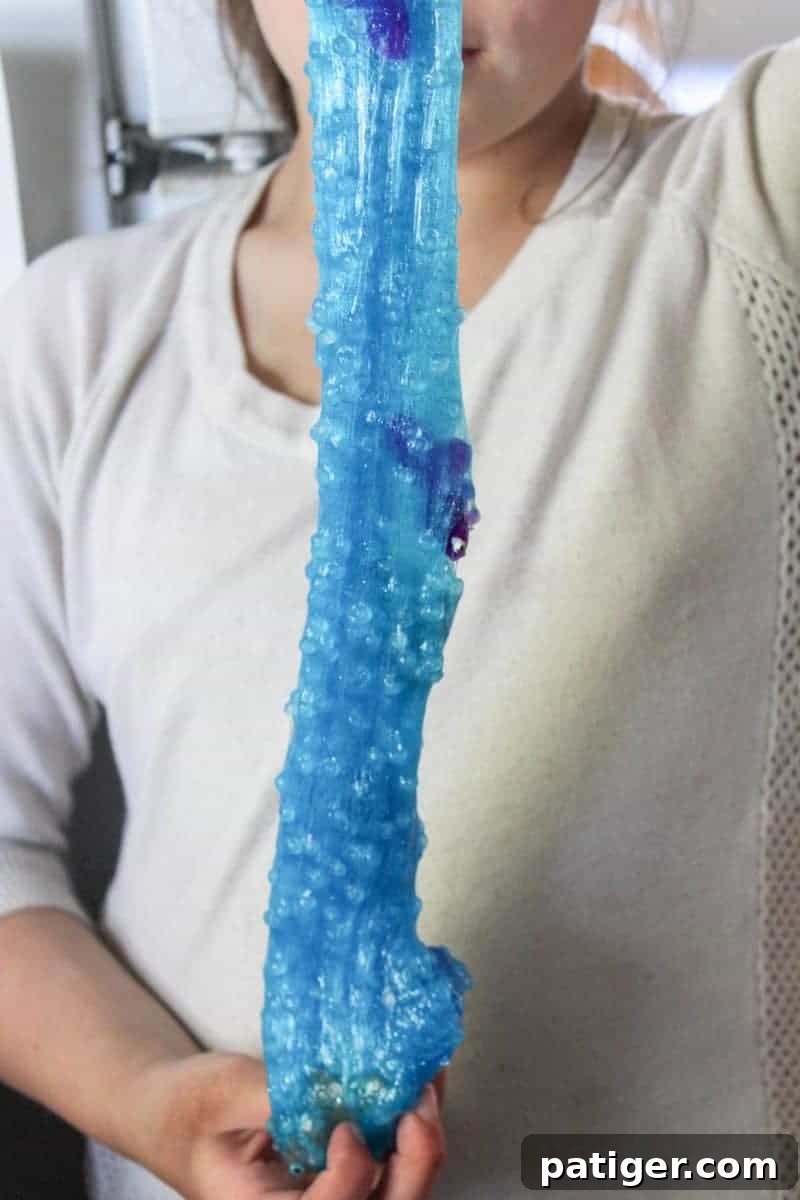 A vibrant display of blue ocean slime with fishbowl beads and plastic fish, showcasing the finished product.