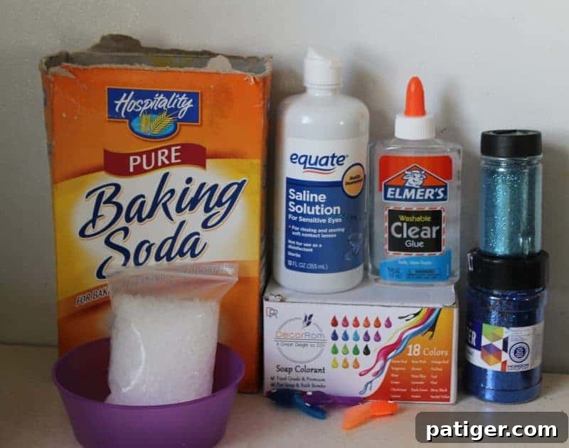 Ingredients and tools laid out for making under the sea ocean slime, including clear glue, glitter, and fishbowl beads.