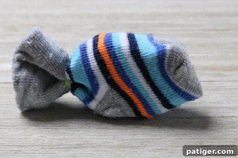 Step 2: A baby sock stuffed with paper, ready to be tied for a DIY cat toy.