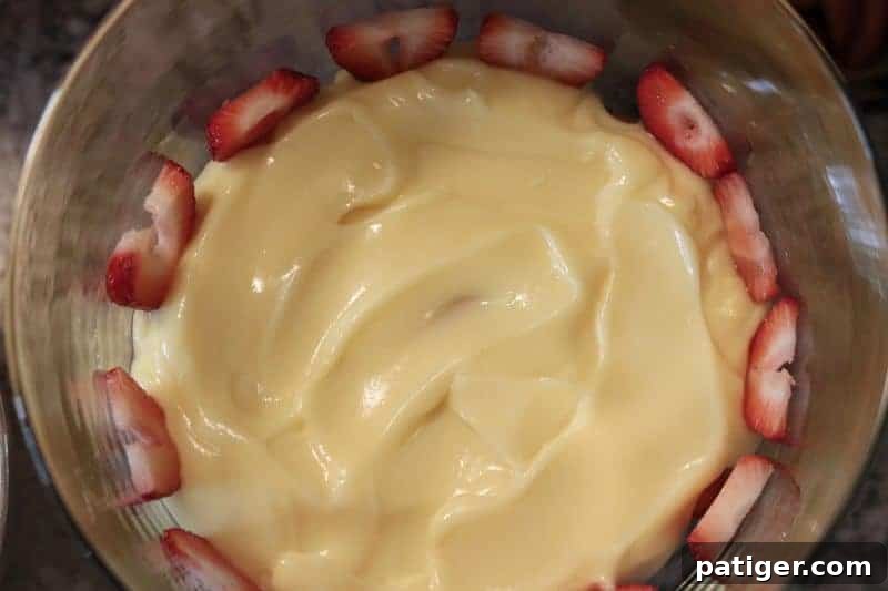 Stars and Stripes Berry Trifle 6 A layer of vanilla pudding topped with fresh berries, with sliced strawberries pressed against the glass in a berry trifle.