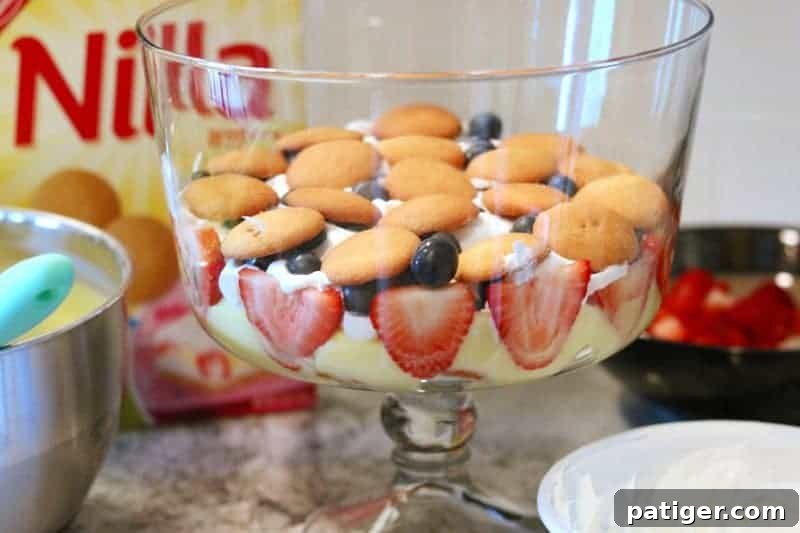 Stars and Stripes Berry Trifle 8 A layer of Nilla Wafers added over whipped topping and berries in the assembly of a berry trifle.