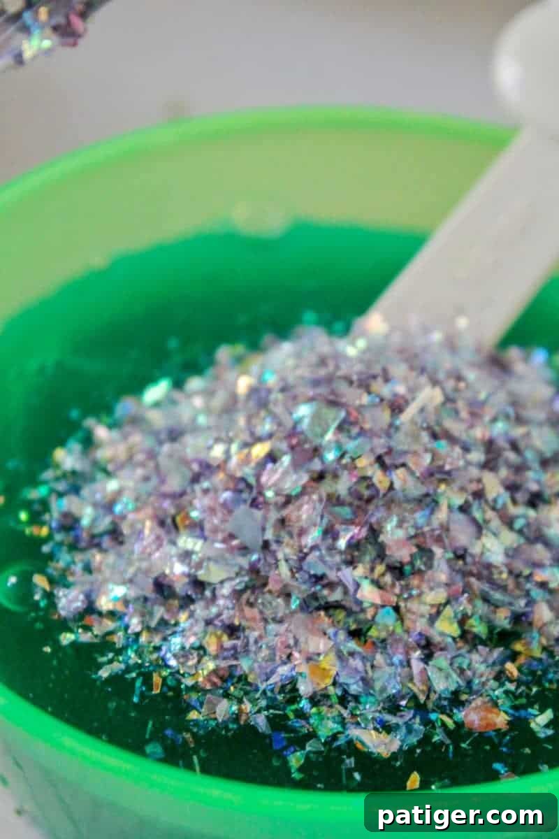 Step 5: Adding glitter to the colored slime mixture for a sparkling effect.