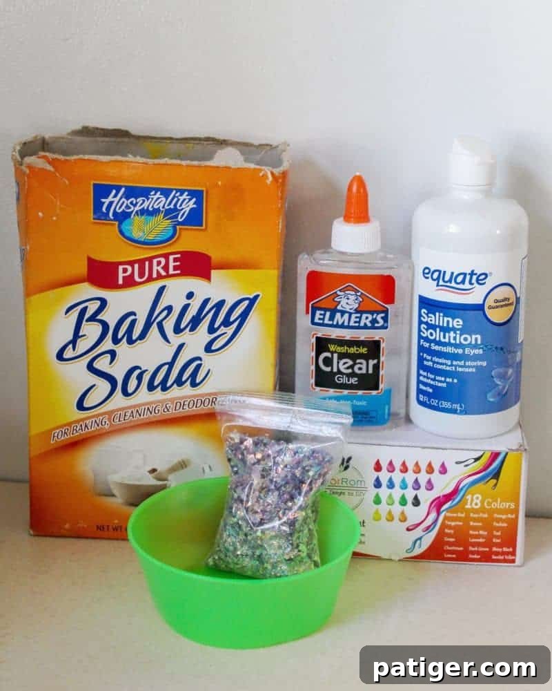 Ingredients laid out for making borax-free mermaid slime, including glue, glitter, and colorant.