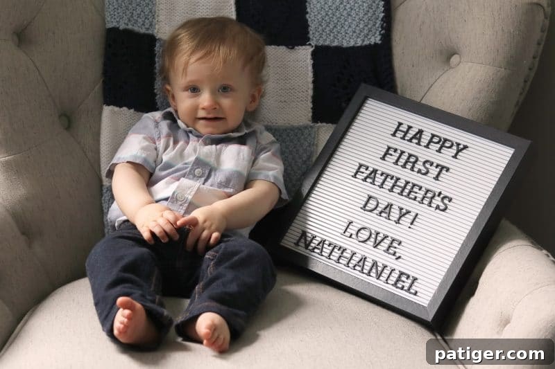 8 Heartwarming Ways to Celebrate a New Dad's First Father's Day 11 Baby holding 'Happy First Father's Day!' sign for a cherished photo memento